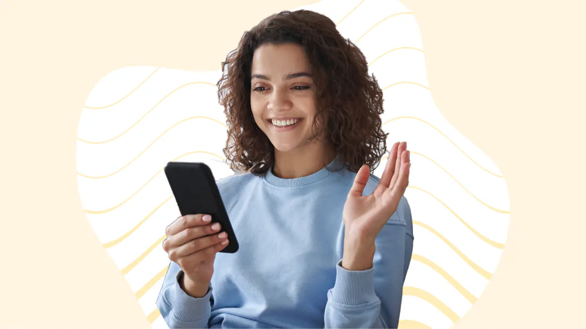 Jente som smiler med en mobiltelefon og en abstrakt lys gul bakgrunn